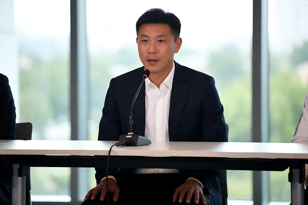 赛后新闻发布会上教练接受采访的场景