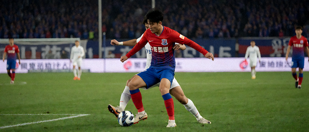 足球比赛夜间直播画面，球场中央球员争抢镜头